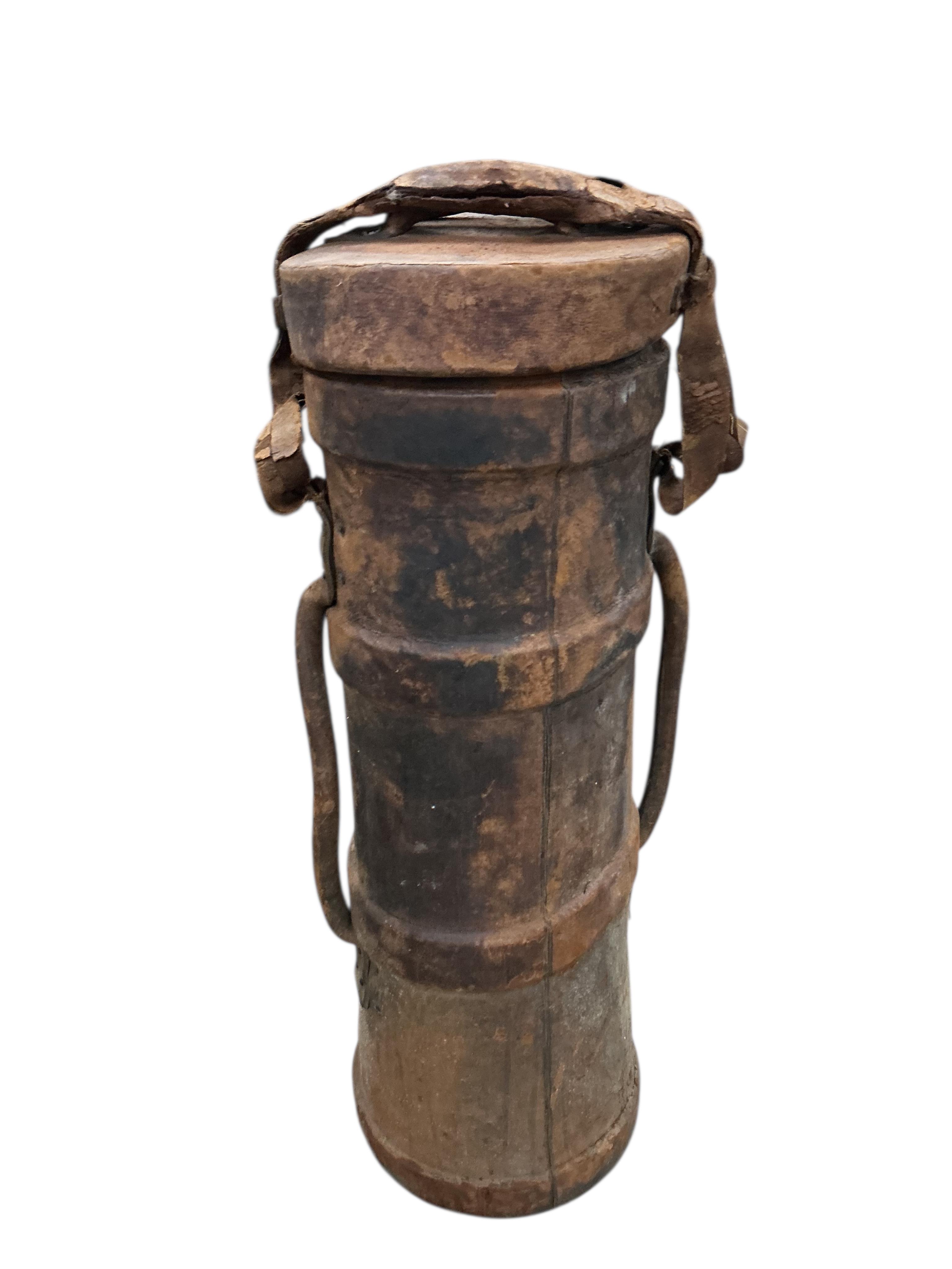 A WWI leather artillery shell case carrier, height 98cm, a wicker laundry hamper and a Revelation leather case